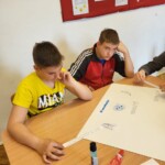 Gyerekek vetélkedő feladatot oldanak meg a tanteremben
